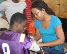 A woman places a blood pressure cuff on a young man