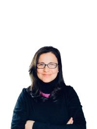 Laura in a black shirt and glasses looking at the camera and smiling.